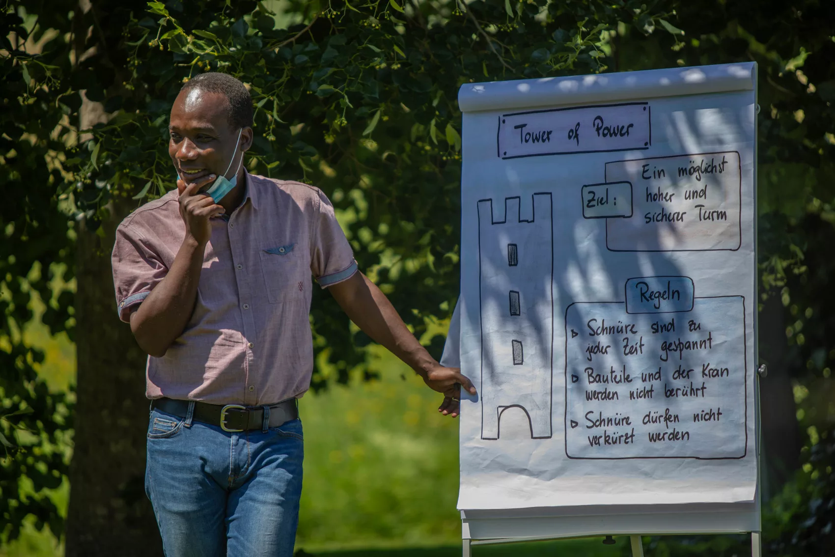 Pierre Michel Ernest erklärt im Freien eine Teamübung am Flipchart